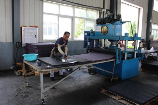 Skilled Worker Brushes Glue on the Back of Rubber Rolls